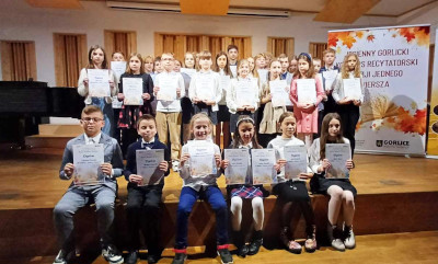 Uczniowie z&nbsp;dyplomami na konkursie recytatorskim. Część stoi a&nbsp;część siedzi