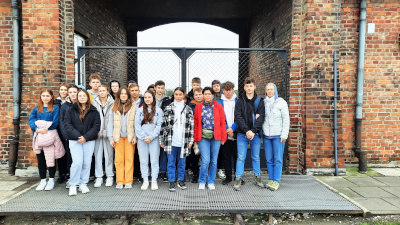 Uczniowie na tle budynku z&nbsp;czerwonej cegły w&nbsp;w Auschwitz-Birkenau