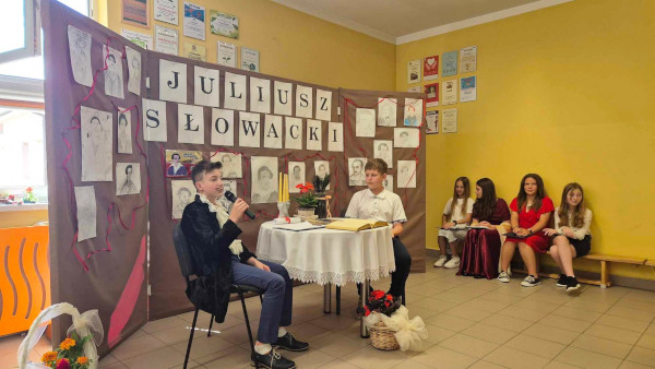 Dwóch uczniów siedzi przy stole. Jeden wcielił się w&nbsp;rolę Juliusza Słowackiego, a&nbsp;drugi w&nbsp;rolę ucznia.