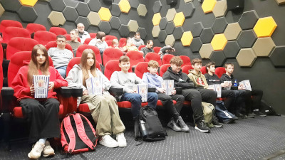Uczniowie klasy ósmej w sali kina 'Kolory' oczekując na seans filmowy