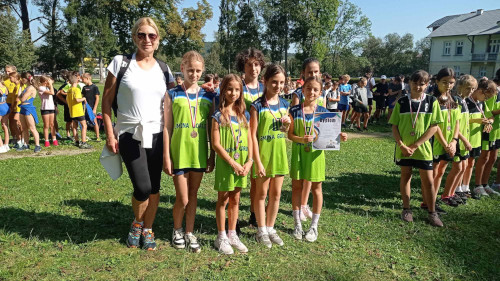 Sześć uczennic z medalami pozuje do zdjęcia z nauczycielką.