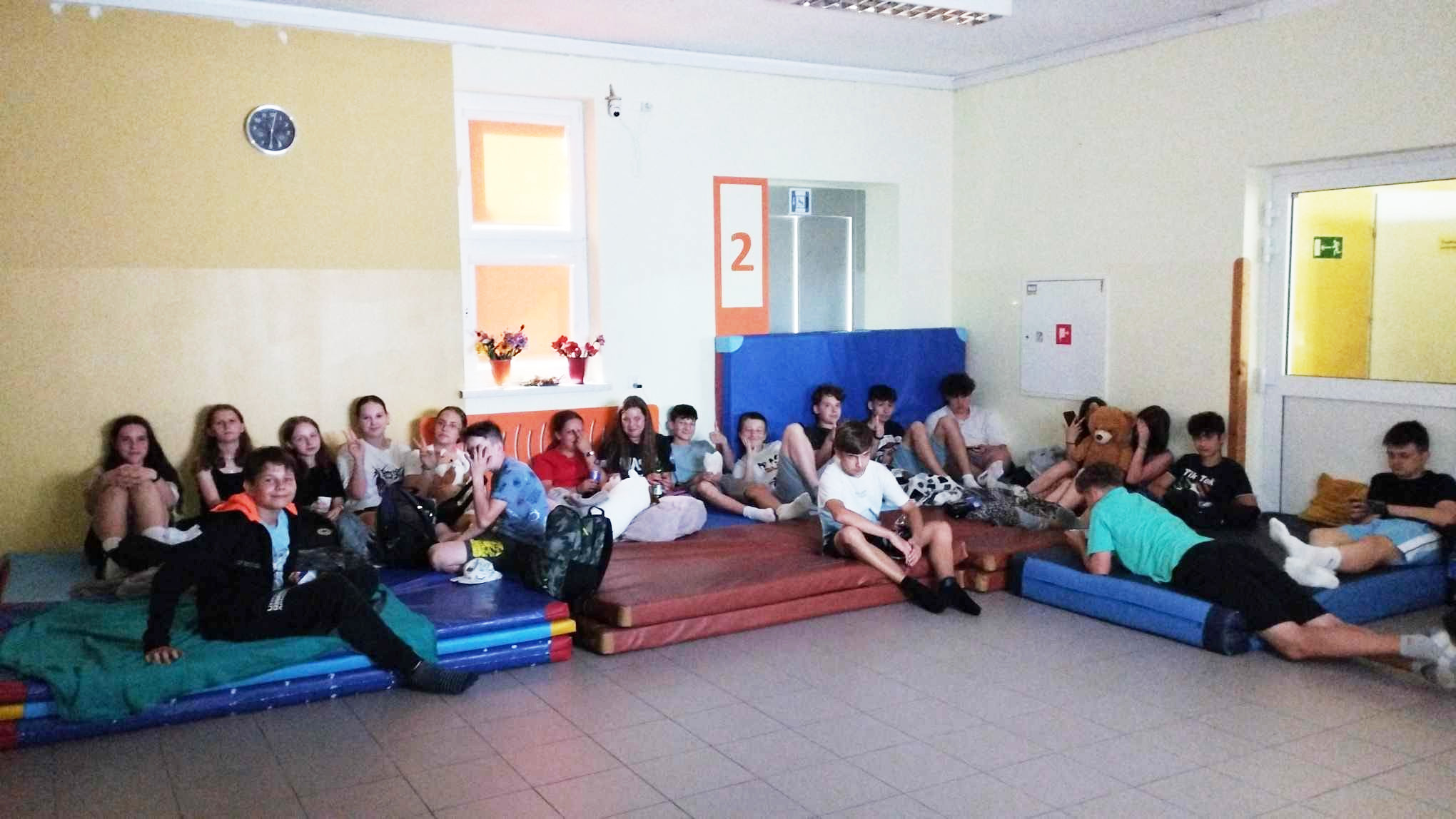 Uczniowie uczestniczący w&nbsp;wieczorze filmowym leżą na szkolnych materacach gimnastycznych, na tzw. przewiązce szkolnej i&nbsp;oglądają projekcję filmową.